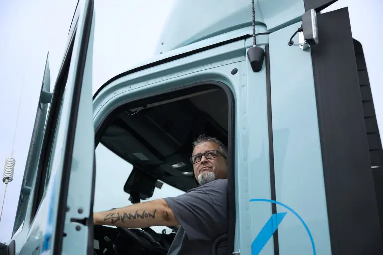 A man leaning out of a Keller Truck.